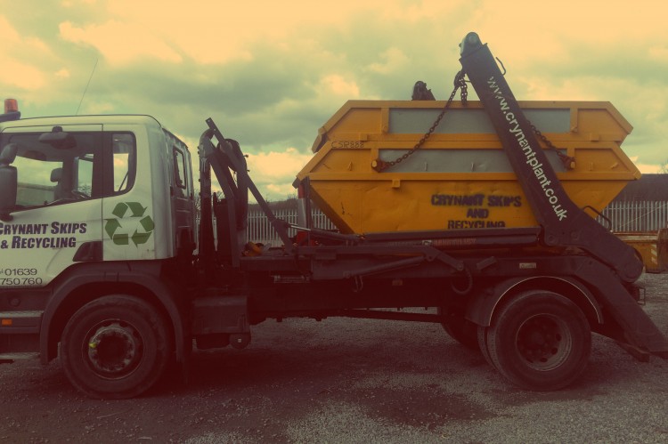 Two yellow Crynant large skips mounted on the back of one of our delivery trucks.
