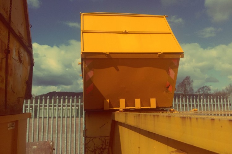 A yellow Crynant enclosed, lockable skip in the storage yard.